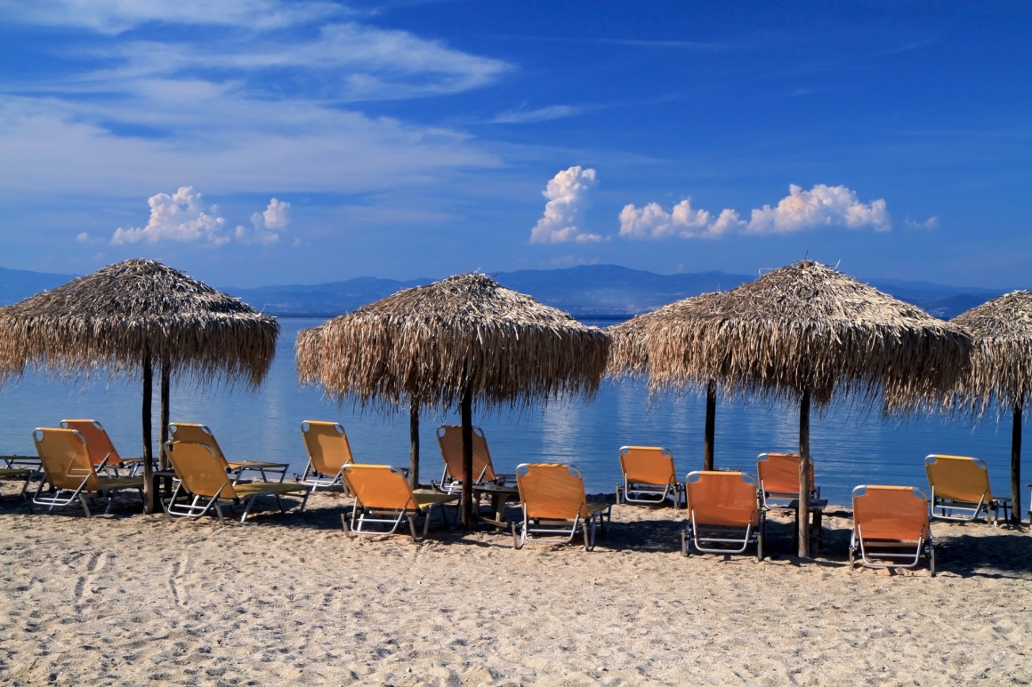 'Greece. Kos island. Tigaki beach.Two chairs and umbrella on the white sand beach' - Kos